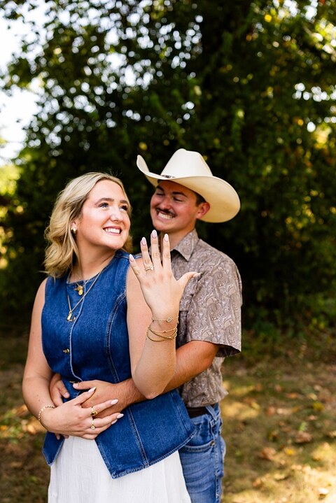 Tyler proposing to Rachel at Chandler Hill Vineyards in Defiance Missouri
Couple standing back to back moments before the surprise proposal
Rachel crying with joy as Tyler kneels during the proposal
Newly engaged couple hugging surrounded by vineyard scenery
Close up of engagement ring in front of rolling vineyard hills