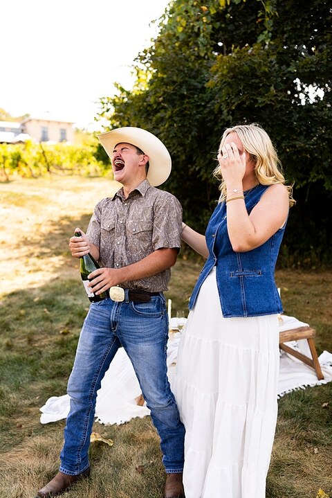 Tyler proposing to Rachel at Chandler Hill Vineyards in Defiance Missouri
Couple standing back to back moments before the surprise proposal
Rachel crying with joy as Tyler kneels during the proposal
Newly engaged couple hugging surrounded by vineyard scenery
Close up of engagement ring in front of rolling vineyard hills