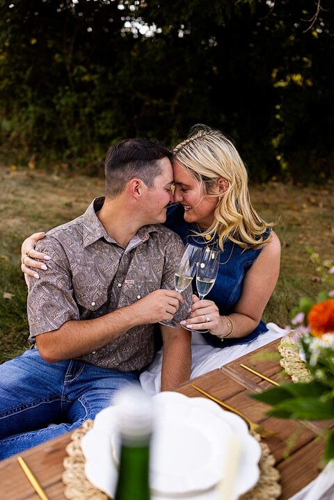 Tyler proposing to Rachel at Chandler Hill Vineyards in Defiance Missouri
Couple standing back to back moments before the surprise proposal
Rachel crying with joy as Tyler kneels during the proposal
Newly engaged couple hugging surrounded by vineyard scenery
Close up of engagement ring in front of rolling vineyard hills