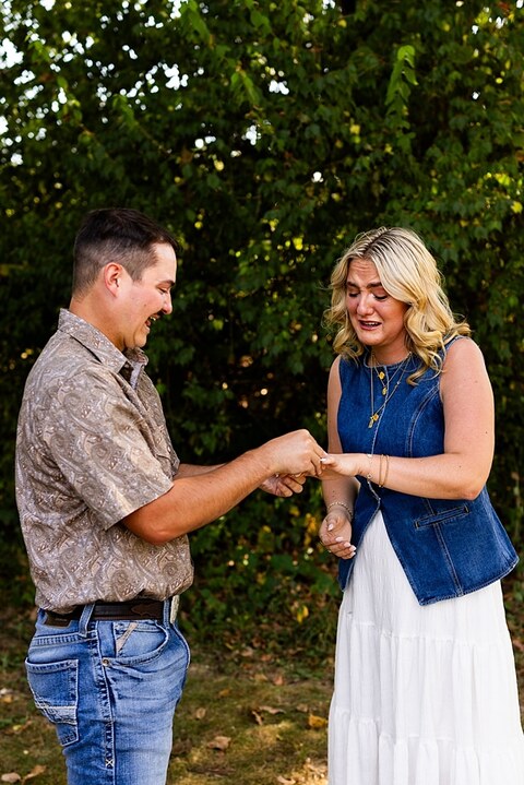 Tyler proposing to Rachel at Chandler Hill Vineyards in Defiance Missouri
Couple standing back to back moments before the surprise proposal
Rachel crying with joy as Tyler kneels during the proposal
Newly engaged couple hugging surrounded by vineyard scenery
Close up of engagement ring in front of rolling vineyard hills