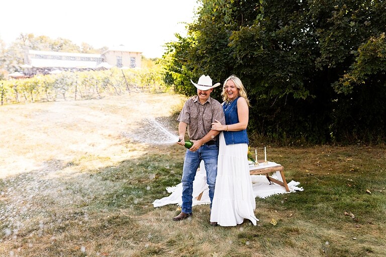 Tyler proposing to Rachel at Chandler Hill Vineyards in Defiance Missouri
Couple standing back to back moments before the surprise proposal
Rachel crying with joy as Tyler kneels during the proposal
Newly engaged couple hugging surrounded by vineyard scenery
Close up of engagement ring in front of rolling vineyard hills