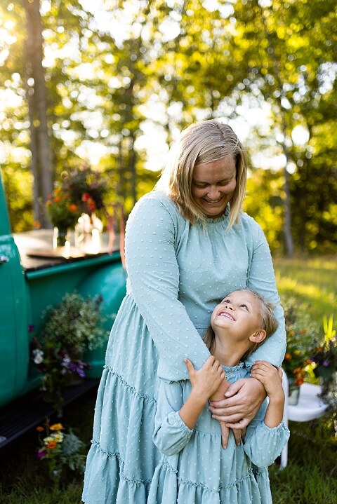 Mother and daughter laughing together during flower truck session in High Hill Missouri