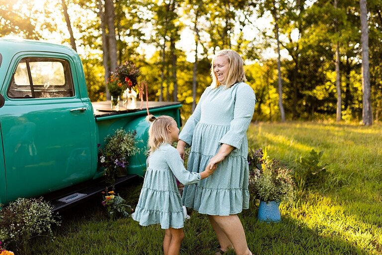 Mother and daughter laughing together during flower truck session in High Hill Missouri