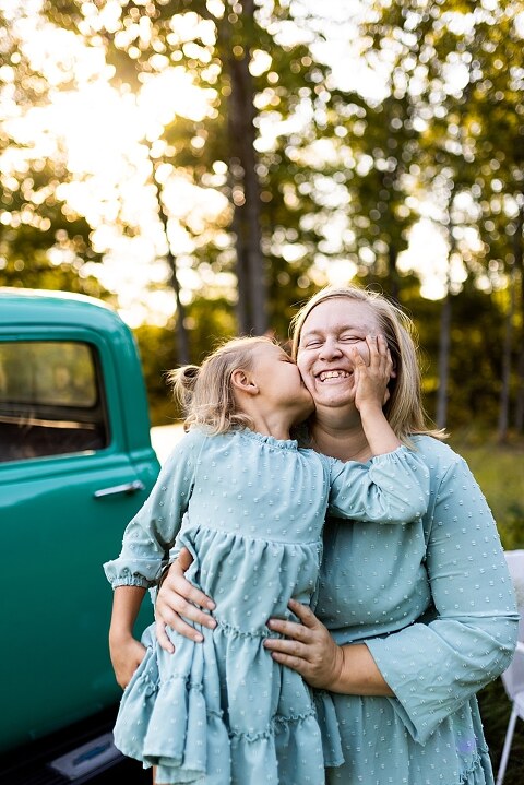 Mother and daughter laughing together during flower truck session in High Hill Missouri