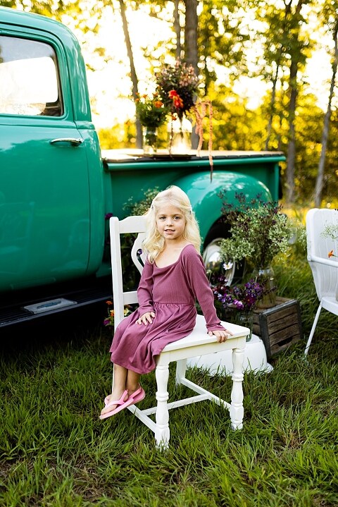 Blended family near teal vintage truck and fresh wildflowers in High Hill Missouri at golden hour