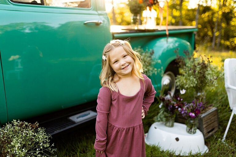 Blended family near teal vintage truck and fresh wildflowers in High Hill Missouri at golden hour