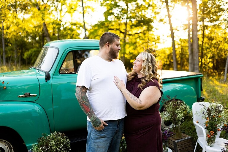 Blended family near teal vintage truck and fresh wildflowers in High Hill Missouri at golden hour