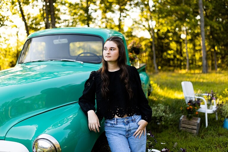 High school senior with teal truck and wildflowers during golden hour in High Hill Missouri