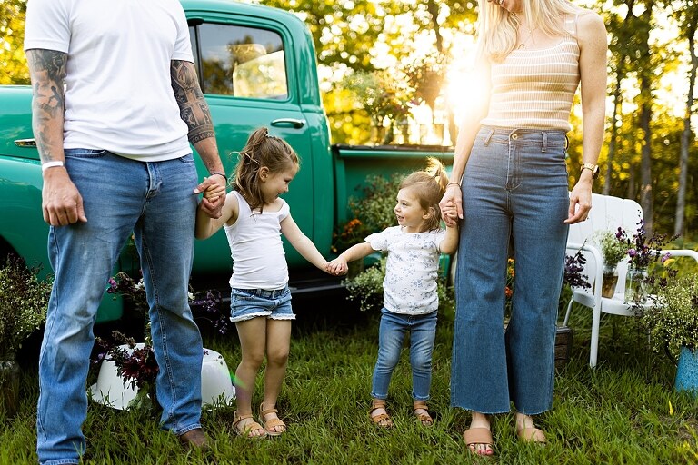 Family posing near teal vintage truck with wildflowers in Warrenton Missouri