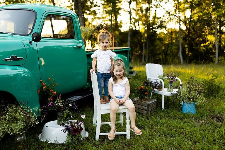 Family posing near teal vintage truck with wildflowers in Warrenton Missouri
