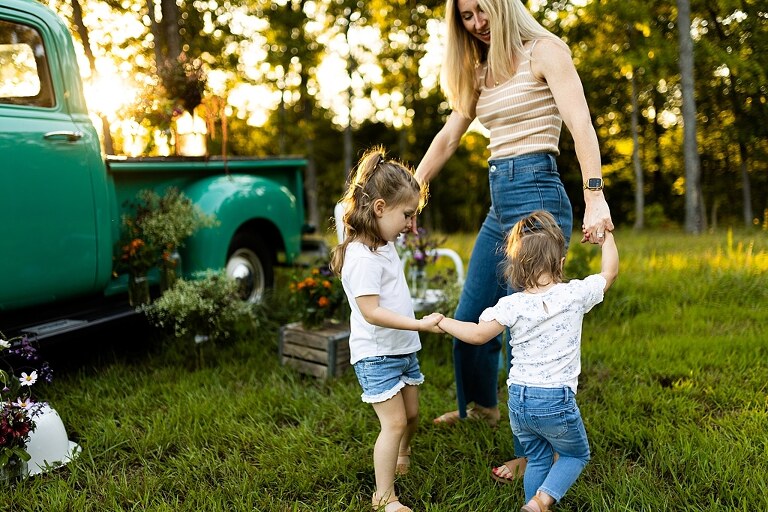 Family posing near teal vintage truck with wildflowers in Warrenton Missouri
