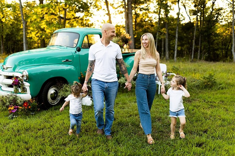 Family posing near teal vintage truck with wildflowers in Warrenton Missouri Family Flower Truck Mini Session