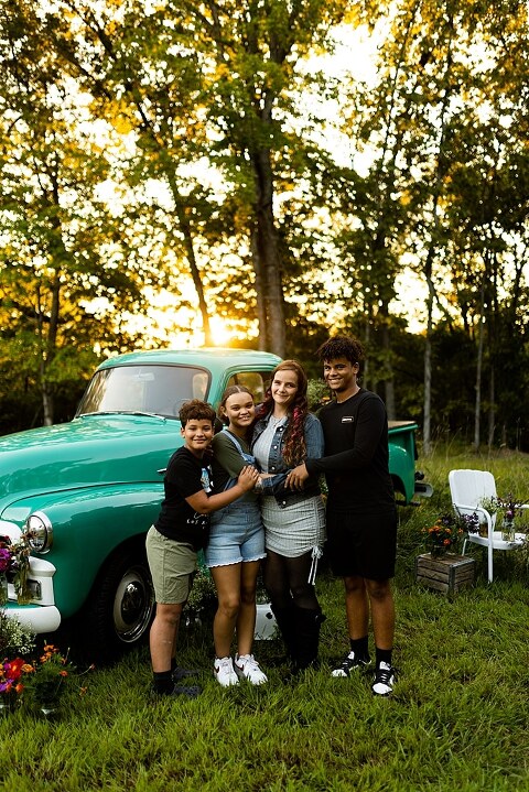 Family hugging with their mother during flower truck session in High Hill Missouri
