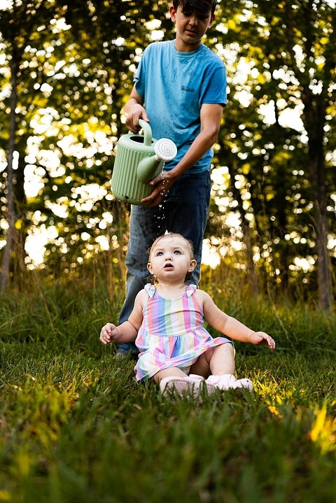 Playful family photo session in High Hill Missouri with mom and four kids enjoying bubbles, sprinkler fun, mud, and sunshine during summertime minis.