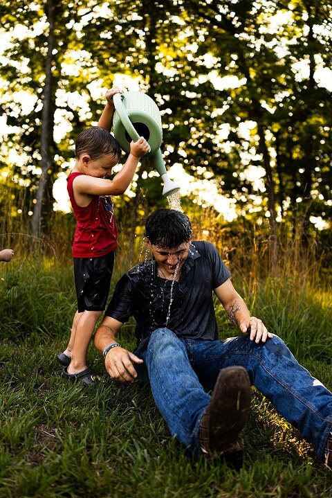 Playful family photo session in High Hill Missouri with mom and four kids enjoying bubbles, sprinkler fun, mud, and sunshine during summertime minis.