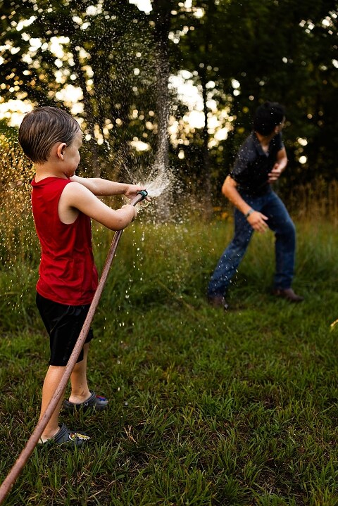 Playful family photo session in High Hill Missouri with mom and four kids enjoying bubbles, sprinkler fun, mud, and sunshine during summertime minis.