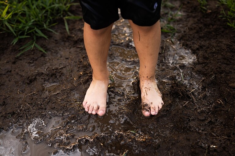 Playful family photo session in High Hill Missouri with mom and four kids enjoying bubbles, sprinkler fun, mud, and sunshine during summertime minis.