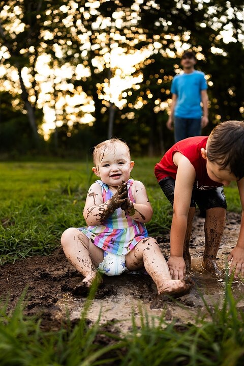 Playful family photo session in High Hill Missouri with mom and four kids enjoying bubbles, sprinkler fun, mud, and sunshine during summertime minis.