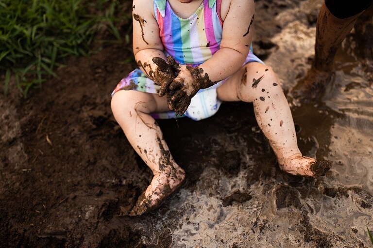 Playful family photo session in High Hill Missouri with mom and four kids enjoying bubbles, sprinkler fun, mud, and sunshine during summertime minis.