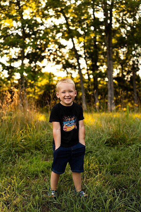 Mom and young son playing together outdoors during summertime mini session, blowing bubbles, splashing water, and sharing joyful moments in the sunshine.