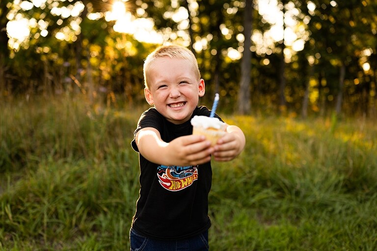 Mom and young son playing together outdoors during summertime mini session, blowing bubbles, splashing water, and sharing joyful moments in the sunshine.