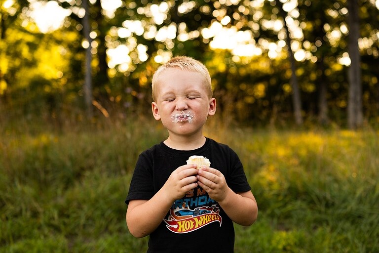 Mom and young son playing together outdoors during summertime mini session, blowing bubbles, splashing water, and sharing joyful moments in the sunshine.