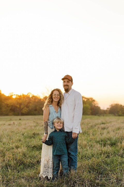 Family standing together in a warm country field during their 90’s style session.
Parents holding their kids with soft golden light behind them.
Family walking through a field during a country-inspired photo shoot.
Close-up of parents smiling during their session with Taylor Ligon Photography.
Kids laughing while standing between their parents in a sunny field.
