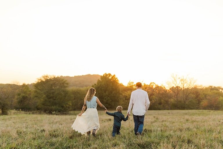 Family standing together in a warm country field during their 90’s style session.
Parents holding their kids with soft golden light behind them.
Family walking through a field during a country-inspired photo shoot.
Close-up of parents smiling during their session with Taylor Ligon Photography.
Kids laughing while standing between their parents in a sunny field.