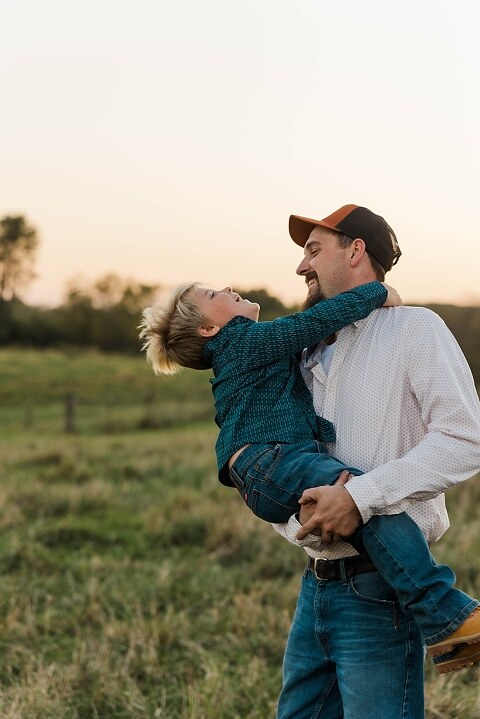 Family standing together in a warm country field during their 90’s style session.
Parents holding their kids with soft golden light behind them.
Family walking through a field during a country-inspired photo shoot.
Close-up of parents smiling during their session with Taylor Ligon Photography.
Kids laughing while standing between their parents in a sunny field.