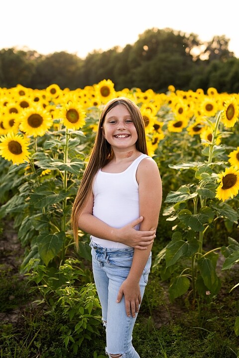 Kids laughing together in a sunflower field during summer family photos | Children exploring sunflowers during family session in Missouri | Missouri photographer Missouri outdoor photographer warrenton MO Jonesburg Montgomery 