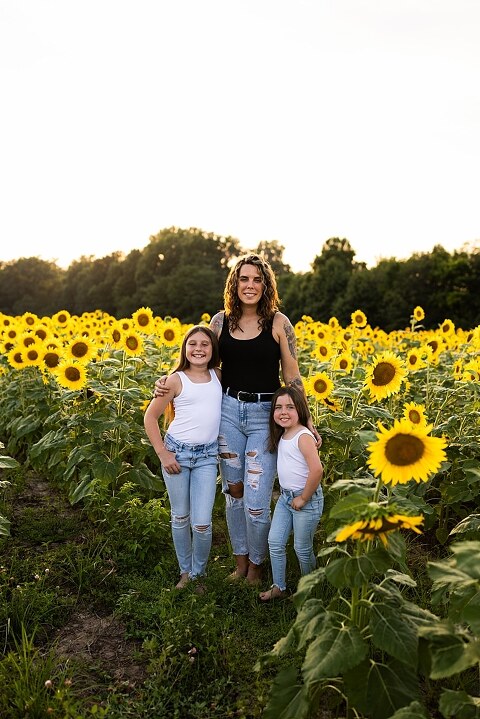Kids laughing together in a sunflower field during summer family photos | Children exploring sunflowers during family session in Missouri | Missouri photographer Missouri outdoor photographer warrenton MO Jonesburg Montgomery 