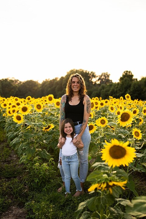 Kids laughing together in a sunflower field during summer family photos | Children exploring sunflowers during family session in Missouri | Missouri photographer Missouri outdoor photographer warrenton MO Jonesburg Montgomery 