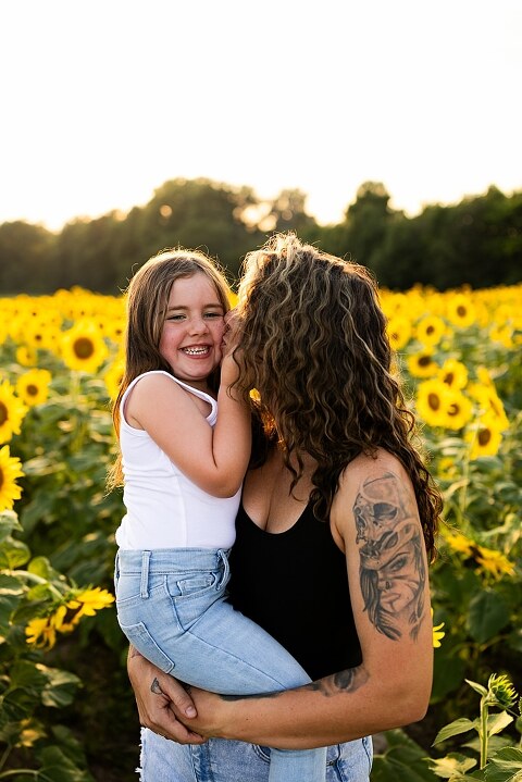 Kids laughing together in a sunflower field during summer family photos | Children exploring sunflowers during family session in Missouri | Missouri photographer Missouri outdoor photographer warrenton MO Jonesburg Montgomery 