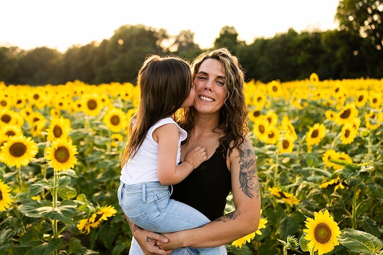 Kids laughing together in a sunflower field during summer family photos | Children exploring sunflowers during family session in Missouri | Missouri photographer Missouri outdoor photographer warrenton MO Jonesburg Montgomery 