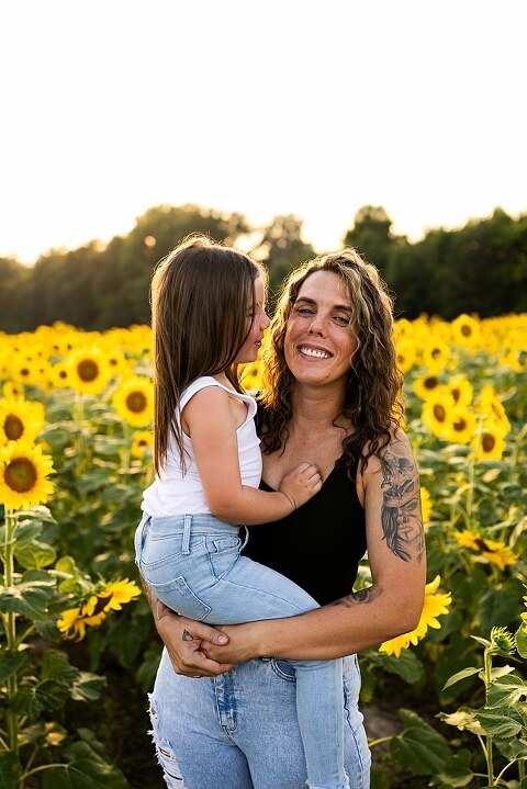 Kids laughing together in a sunflower field during summer family photos | Children exploring sunflowers during family session in Missouri | Missouri photographer Missouri outdoor photographer warrenton MO Jonesburg Montgomery 