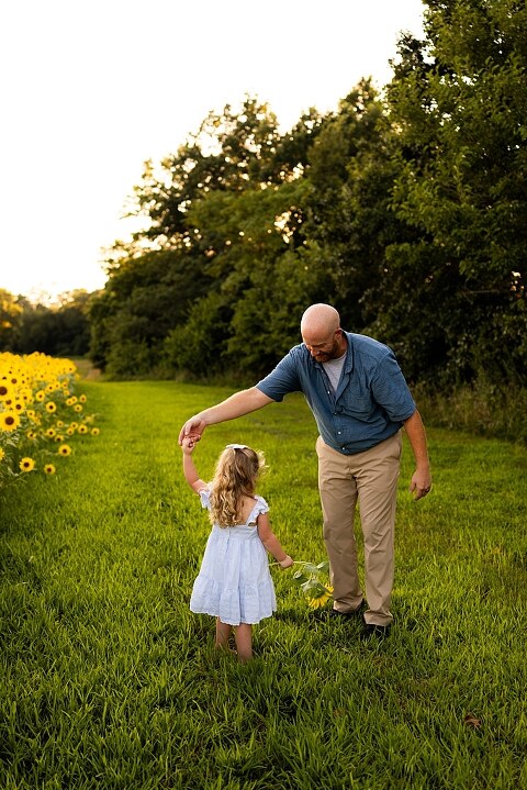 Family of four during sunflower mini photo session in Jonesburg Missouri | Kids smiling in sunflower field during family tradition photo shoot | Family cuddles in sunflower field during summer photos | Missouri Photographer | Outdoor photographer 