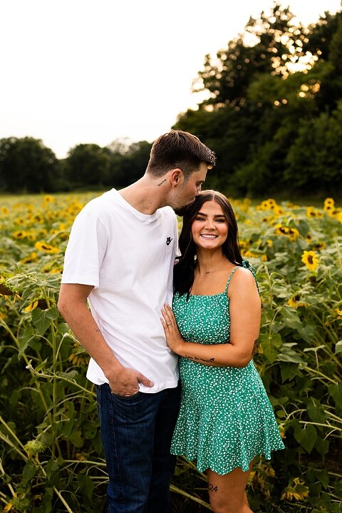 Family of three smiling together in a bright sunflower field during summer | Little boy grinning while standing among tall sunflowers
 | Parents holding their son and laughing in golden evening light | Family hugging closely surrounded by blooming sunflowers