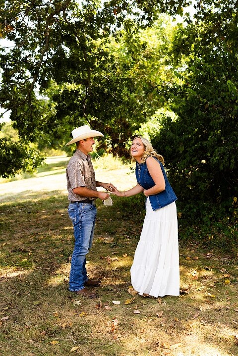 Tyler proposing to Rachel at Chandler Hill Vineyards in Defiance Missouri
Couple standing back to back moments before the surprise proposal
Rachel crying with joy as Tyler kneels during the proposal
Newly engaged couple hugging surrounded by vineyard scenery
Close up of engagement ring in front of rolling vineyard hills
