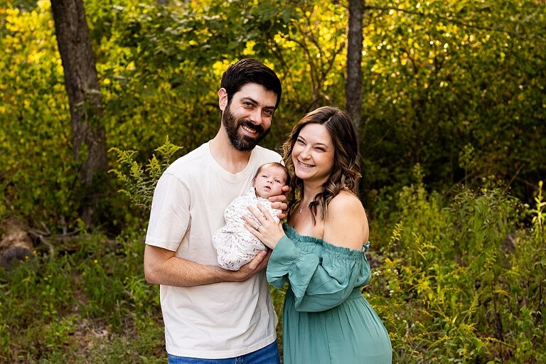 New parents holding their newborn girl outside in soft September light
Mother cradling newborn during an outdoor in home lifestyle session
Father smiling while holding baby girl in shaded backyard
Family photo with their dog photobombing in the background
Newborn resting peacefully with a curious kitty peeking nearby