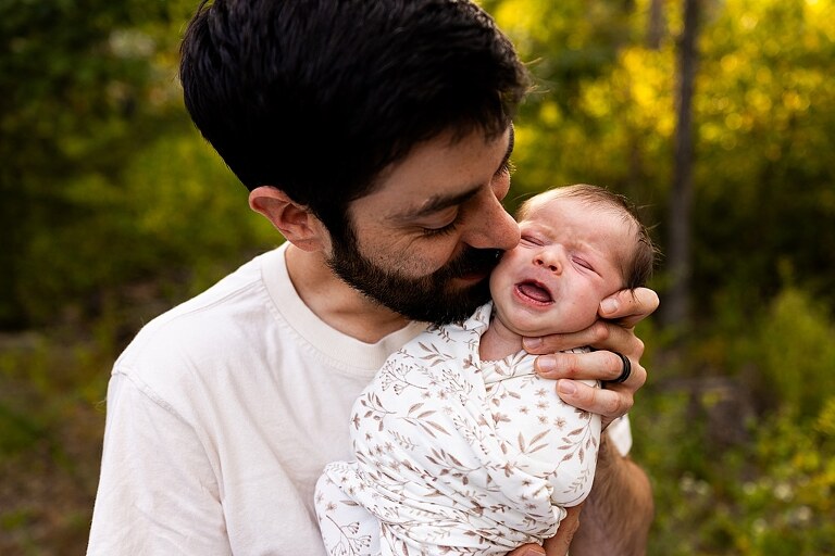 New parents holding their newborn girl outside in soft September light
Mother cradling newborn during an outdoor in home lifestyle session
Father smiling while holding baby girl in shaded backyard
Family photo with their dog photobombing in the background
Newborn resting peacefully with a curious kitty peeking nearby