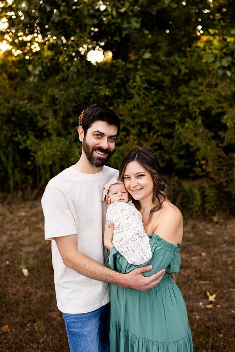 New parents holding their newborn girl outside in soft September light
Mother cradling newborn during an outdoor in home lifestyle session
Father smiling while holding baby girl in shaded backyard
Family photo with their dog photobombing in the background
Newborn resting peacefully with a curious kitty peeking nearby