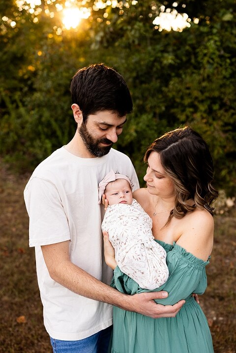 New parents holding their newborn girl outside in soft September light
Mother cradling newborn during an outdoor in home lifestyle session
Father smiling while holding baby girl in shaded backyard
Family photo with their dog photobombing in the background
Newborn resting peacefully with a curious kitty peeking nearby