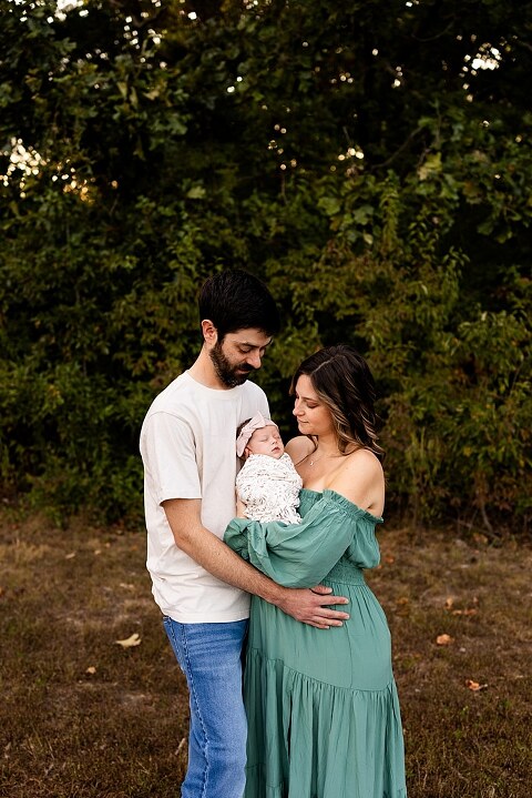 New parents holding their newborn girl outside in soft September light
Mother cradling newborn during an outdoor in home lifestyle session
Father smiling while holding baby girl in shaded backyard
Family photo with their dog photobombing in the background
Newborn resting peacefully with a curious kitty peeking nearby