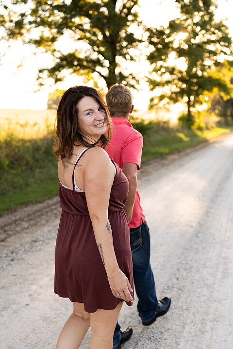 Family walking together through a field in High Hill Missouri
Parents smiling at their child while standing on a gravel road
Child laughing and making a silly face during a family session
Family holding hands in tall grass with warm evening light
Parents hugging their child while standing on a quiet country road