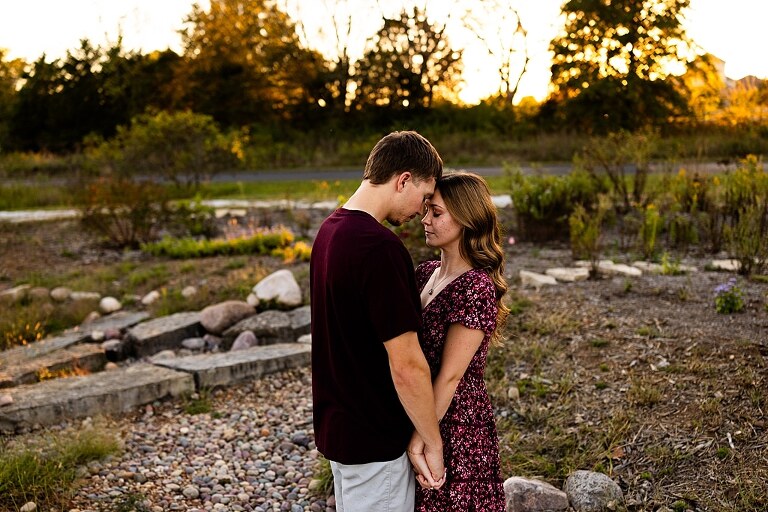 Tyler and Grace standing on a sunlit path at Towne Park during their engagement session.
Couple laughing together in an open field at Towne Park.
Tyler and Grace holding hands along a wooded trail with soft golden light behind them.
Close–up of the couple smiling at each other during their engagement session.
Engagement ring photo taken at Towne Park with natural greenery in the background.