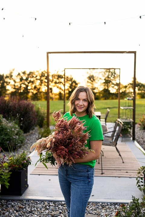 Aimie standing in her flower garden in High Hill Missouri surrounded by colorful blooms.
Close–up of Aimie gently holding freshly cut flowers from her garden.
Wide view of the flower farm with rows of vibrant summer flowers.
Aimie smiling while arranging flowers during her garden session.
Hands holding a bouquet of freshly picked flowers in soft natural light.