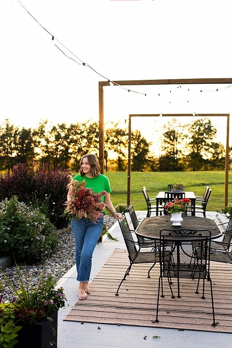 Aimie standing in her flower garden in High Hill Missouri surrounded by colorful blooms.
Close–up of Aimie gently holding freshly cut flowers from her garden.
Wide view of the flower farm with rows of vibrant summer flowers.
Aimie smiling while arranging flowers during her garden session.
Hands holding a bouquet of freshly picked flowers in soft natural light.