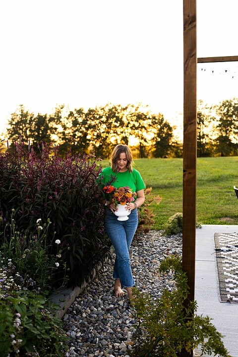 Aimie standing in her flower garden in High Hill Missouri surrounded by colorful blooms.
Close–up of Aimie gently holding freshly cut flowers from her garden.
Wide view of the flower farm with rows of vibrant summer flowers.
Aimie smiling while arranging flowers during her garden session.
Hands holding a bouquet of freshly picked flowers in soft natural light.