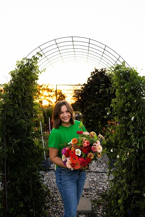 Aimie standing in her flower garden in High Hill Missouri surrounded by colorful blooms.
Close–up of Aimie gently holding freshly cut flowers from her garden.
Wide view of the flower farm with rows of vibrant summer flowers.
Aimie smiling while arranging flowers during her garden session.
Hands holding a bouquet of freshly picked flowers in soft natural light.