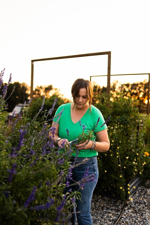 Aimie standing in her flower garden in High Hill Missouri surrounded by colorful blooms.
Close–up of Aimie gently holding freshly cut flowers from her garden.
Wide view of the flower farm with rows of vibrant summer flowers.
Aimie smiling while arranging flowers during her garden session.
Hands holding a bouquet of freshly picked flowers in soft natural light.